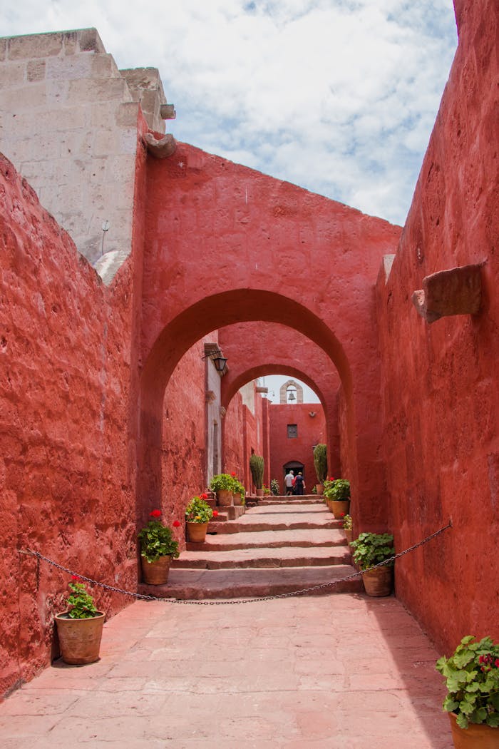 Explore the vibrant red archways of Santa Catalina Monastery in Arequipa, Peru.